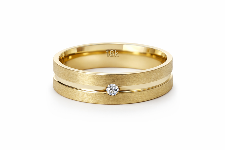 18K Gold Wedding Ring with a single dazzling diamond accent stone set at the center. Flanking the diamond are two brushed finish lines, creating a textured contrast against the polished finish.